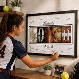A young woman is writing on a framed collage that includes images of sports equipment, such as a football, baseball, and hockey helmet, along with the names of various athletes.