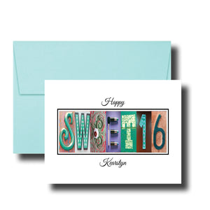 A greeting card with the word "SWEET 16" made up of colorful letters, placed on top of a light blue envelope.