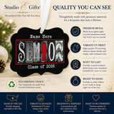 The image is a promotional graphic for Studio & Gifts' personalized gifts. It features a black ornament with the word "SENIOR" written on it, along with various descriptions of the ornament's features, such as premium metal, vibrant UV print, durability, and eco-friendliness. The image also highlights that the ornament is a thoughtful gift that can last a lifetime, and it is made in the USA.