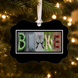 A black ornament with the word "BLAKE" spelled out in a creative and artistic manner, using various objects such as a green bottle, a pair of shoes, and a pair of glasses.