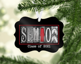 A black ornament hanging from a tree branch with the word "SENIOR" spelled out in a decorative font.