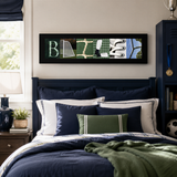 a bedroom with a bed, a nightstand, and a framed artwork on the wall. The artwork is a collage of various images, including a soccer ball, a trophy, and a plant.