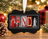 a black ornament with the word "MAND" spelled out in a decorative manner, surrounded by holiday decorations such as a Christmas tree and ornaments.