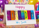 A birthday card with the name "Mrs Smith" written on it, surrounded by colorful confetti and party decorations.