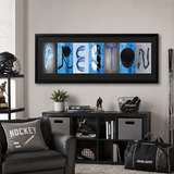 a living room with a framed collage of hockey-related items on the wall, including a hockey helmet, a hockey stick, a hockey puck, and a hockey goalie. The room also contains a black leather chair, a black bag, and a black shelf with books and other items.