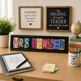 a desk with various items, including a notebook, a mug, a globe, and a framed sign. The desk also has a plant, a pen, and some colorful sticky notes.